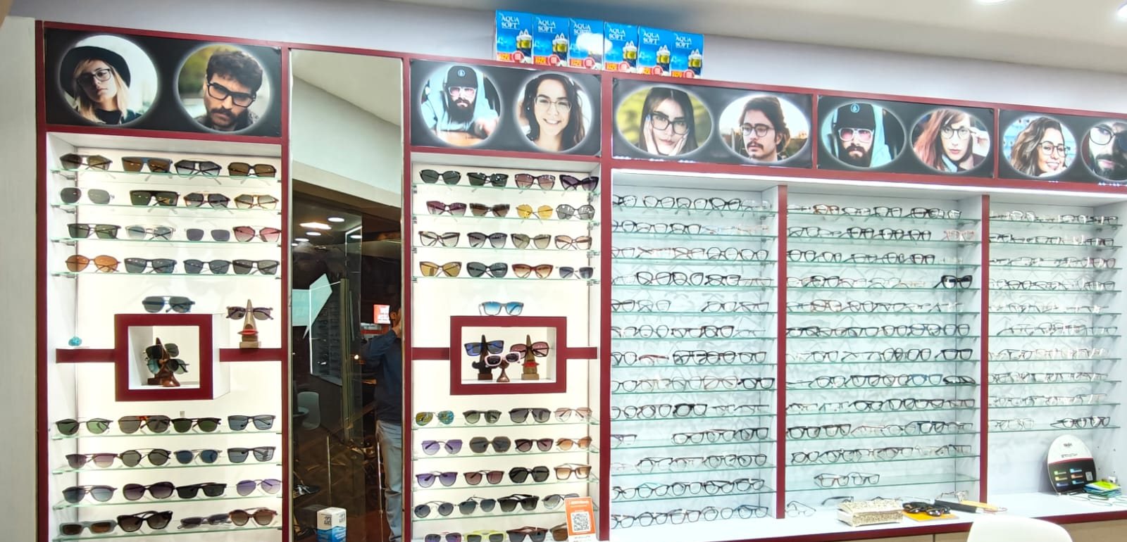 Sunglasses wall with glass shelves and a long wall of optical frames